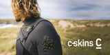 a c skins wetsuit on a surfer